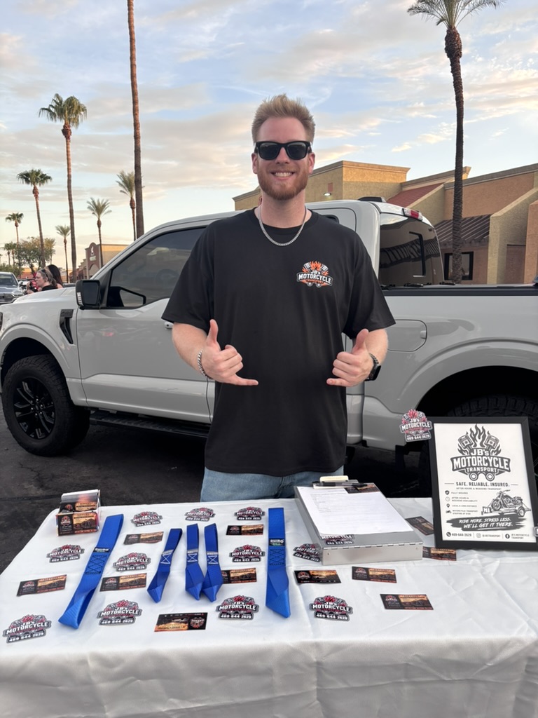 JB's Motorcycle Transport owner standing at the business display in front of his truck